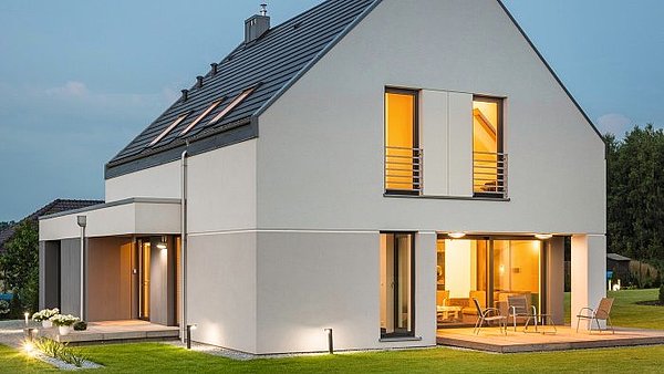 kunststoff-fenster Haus am Abend mit hell erleuchteten Fenstern