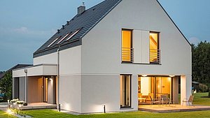 Haus am Abend mit hell erleuchteten Fenstern