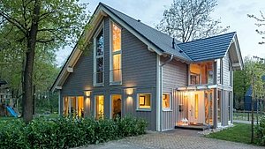 Modernes Holzhaus mit erleuchteten Fenstern